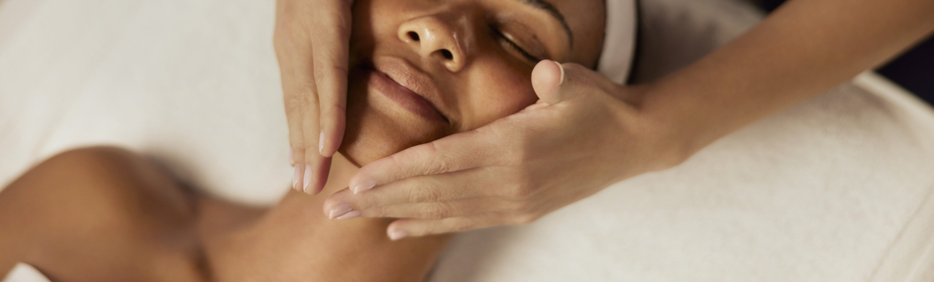 Woman receiving a facial massage in a spa setting