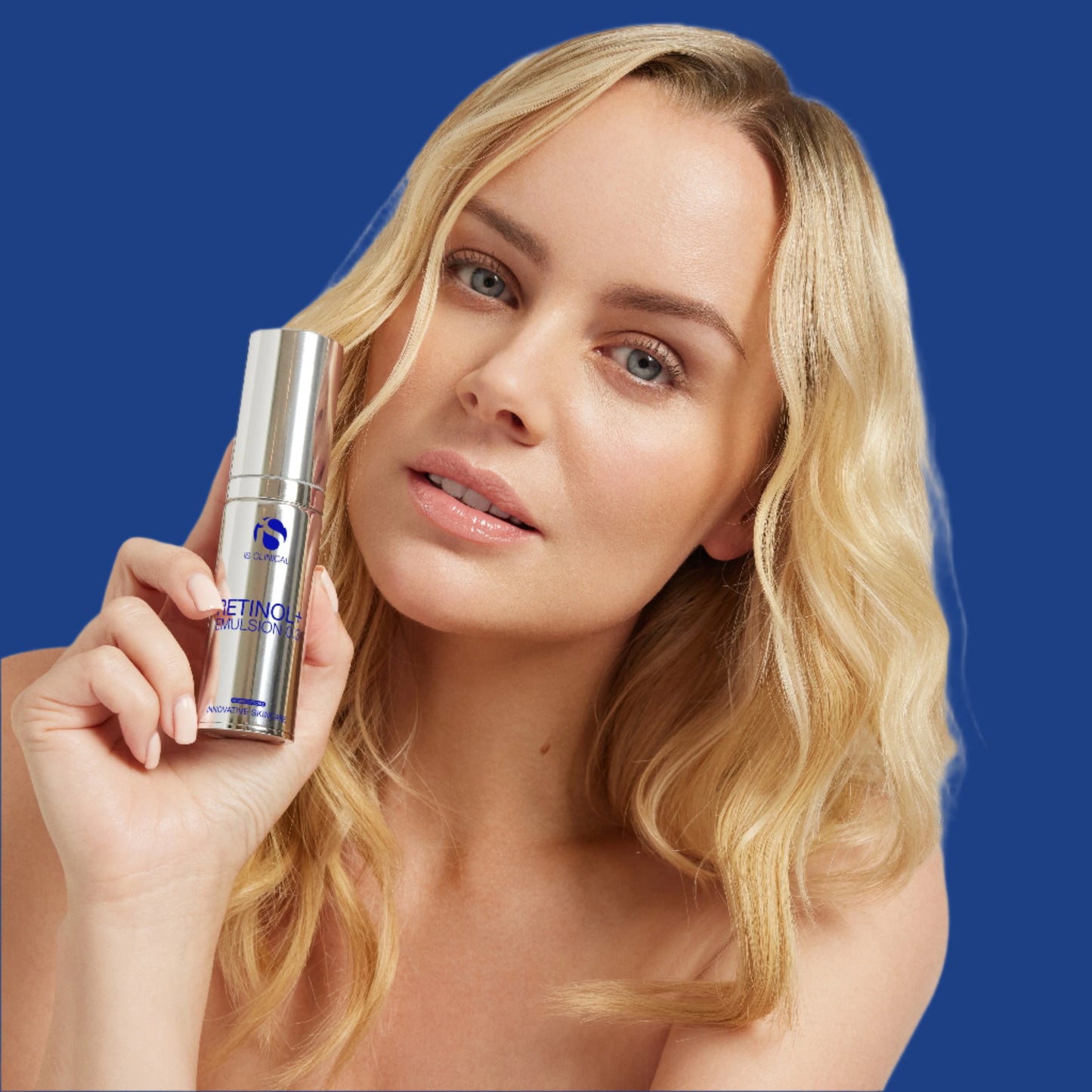Woman holding a skincare product with a plain background